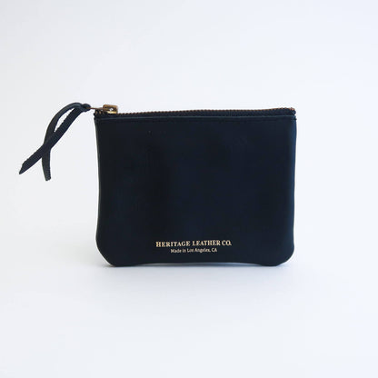 A black leather wallet with a single zip closure with gold foil printed Heritage Leather logo on the front