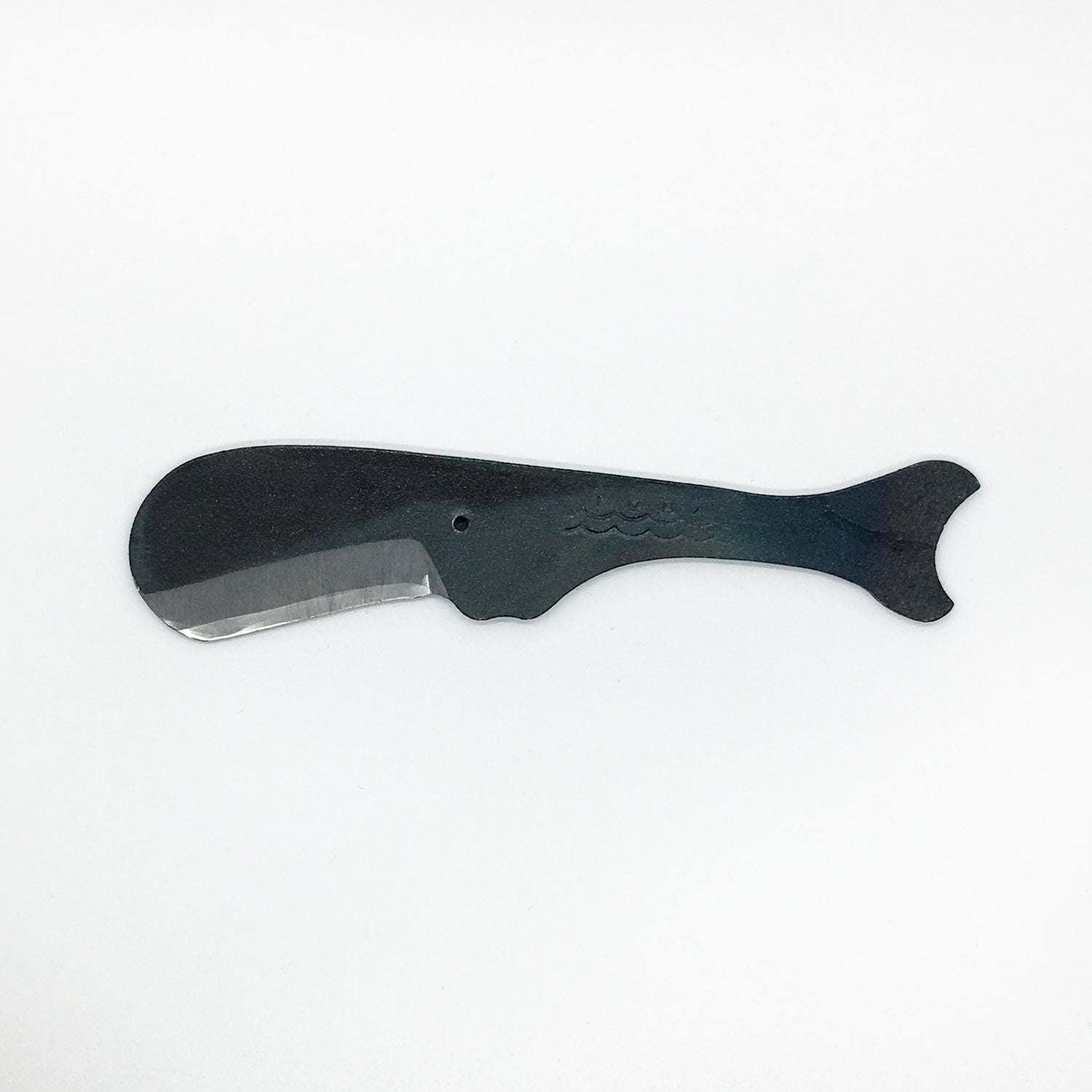 a carbon steel hand knife in the shape of a sperm whale