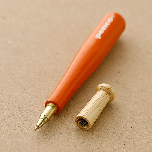 Orange wooden pen that looks like a miniature baseball bat by Penco. White "penco" logo  printed on the orange surface. Open cap that resembles the baseball bat handle reveals the brass ballpoint pen tip.